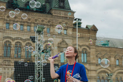 Full length of woman with bubbles in background