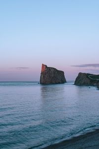 Scenic view of rock formation in sea against sky