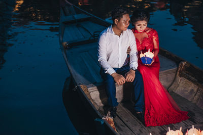 Man holding woman standing in water