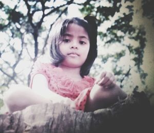 Portrait of cute girl sitting outdoors