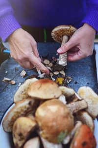 Midsection of person cutting mushrooms on table
