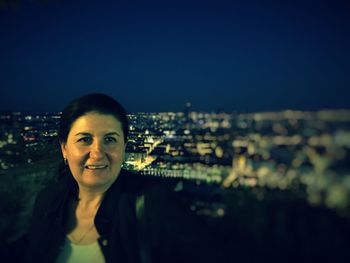 Portrait of woman in city at night