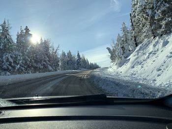 Road seen through car windshield during winter