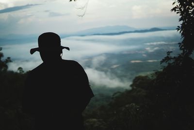 Silhouette man wearing hat against landscape