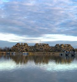 View of buildings in city against cloudy sky