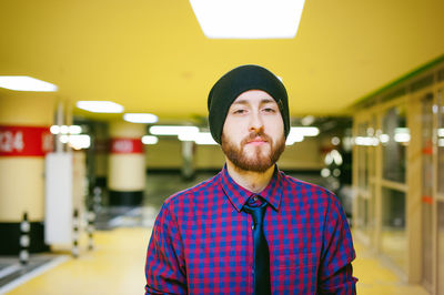 Close-up portrait of young man standing in illuminated parking garage