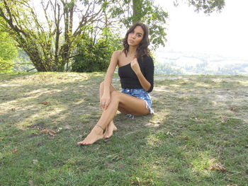 Portrait of young woman sitting on field