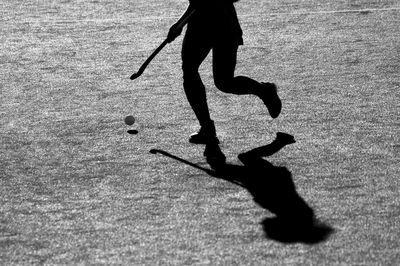 Low section of person playing hockey on field