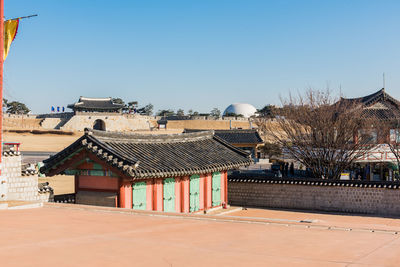 Houses and buildings against clear blue sky