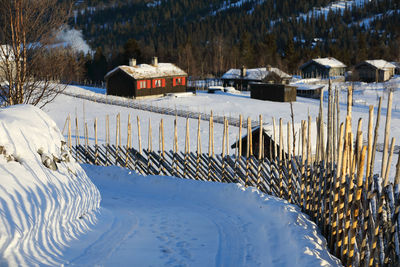 Scenic view of snow covered field by houses