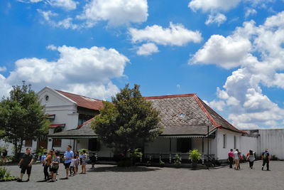 People in front of building against sky