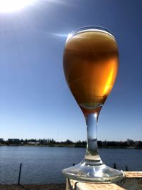 Close-up of beer in sea against clear sky