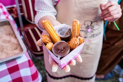 Midsection of woman holding food in container