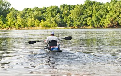 Rear view of man in boat on lake