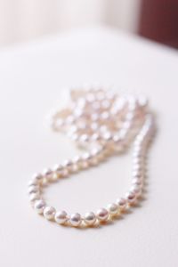 Close-up of necklace on white table