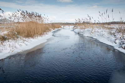 Scenic view of river against sky during winter