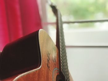 Close-up of guitar against window