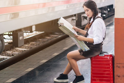 Side view of young woman reading book