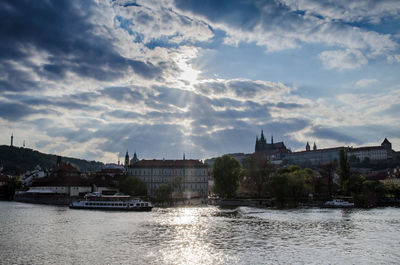 River by cityscape against sky