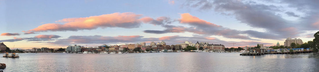 Panoramic view of sea and buildings against sky during sunset