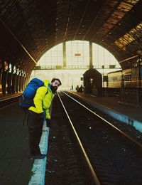 Man standing on railroad station platform during winter