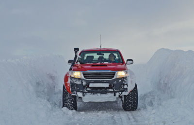 Customised 4x4 pick up truck driving through deep snow