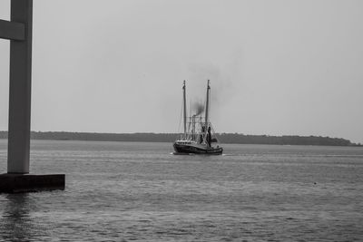 Sailboat sailing on sea against clear sky