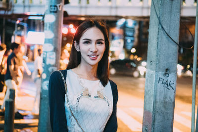 Portrait of smiling young woman standing outdoors