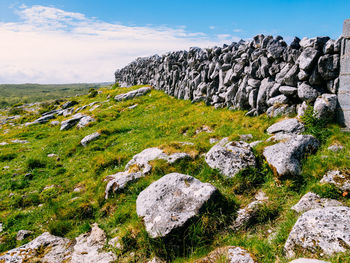 Rocks on grass against sky