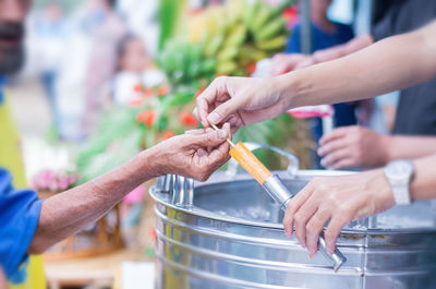 Cropped hands of woman giving food to customer in market