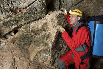 Archaeologist with backpack standing in cave