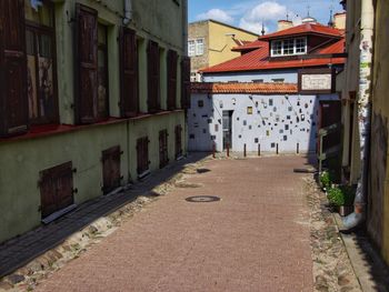 Empty road amidst buildings in city