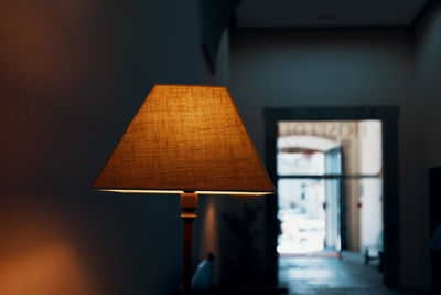 Close-up of illuminated lamp by wall at home