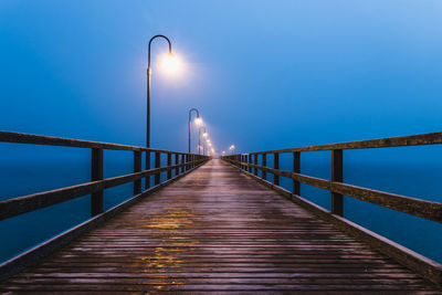 Footbridge over pier against sky