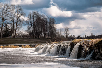 Scenic view of waterfall against sky