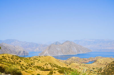Scenic view of landscape and mountains against clear blue sky