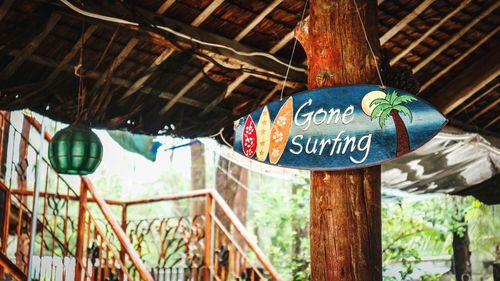 Close-up of sign board hanging on tree