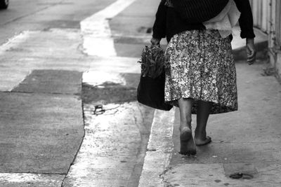 Low section of woman walking on footpath