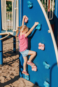 Girl climbing on wall in playground