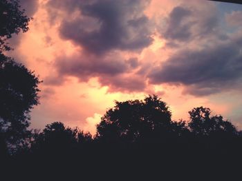 Silhouette of trees against cloudy sky