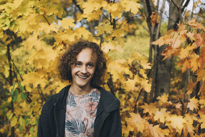 Portrait of smiling young woman with autumn leaves