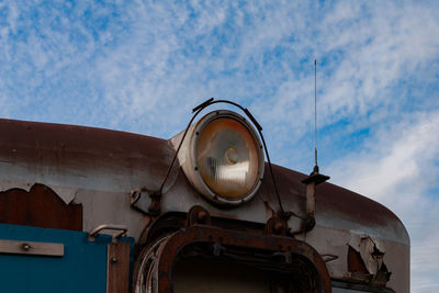 Low angle view of cross on building against sky