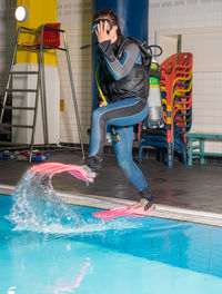 Full length of man scuba diving in swimming pool