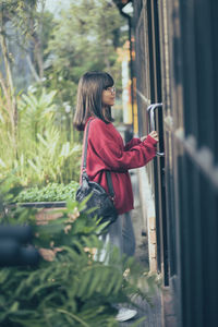 Asian teenager standing against close door