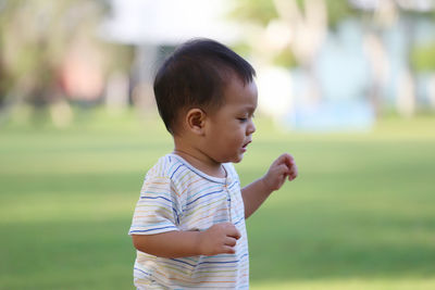 Boy looking away while standing outdoors