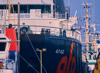 Boats moored at harbor against sky in city