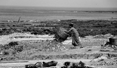 Rear view of woman working on beach