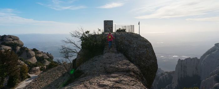 Rear view of woman climbing steps on rock formation