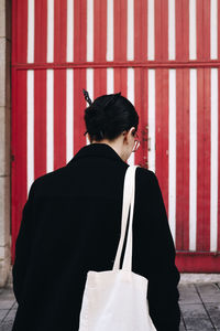 Side view of woman standing against wall