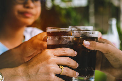 Close-up of people toasting drink outdoors